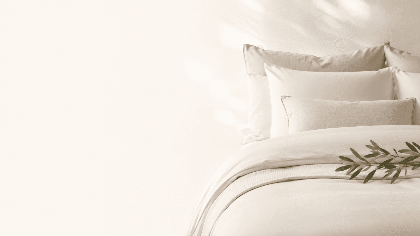 Freshly styled neutral bedding with greenery