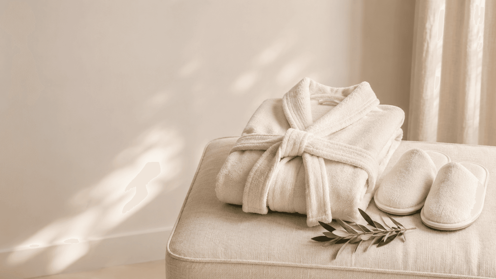 Fresh white towels folded with a sprig of greenery